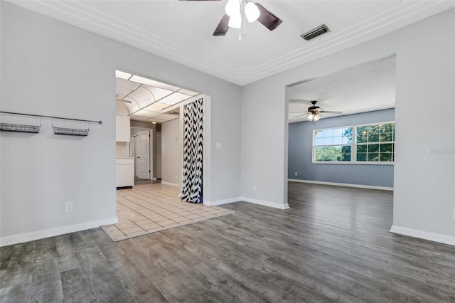 unfurnished room with a ceiling fan, baseboards, visible vents, and wood finished floors