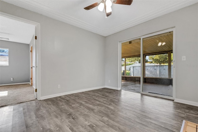 unfurnished room featuring ceiling fan, baseboards, and wood finished floors