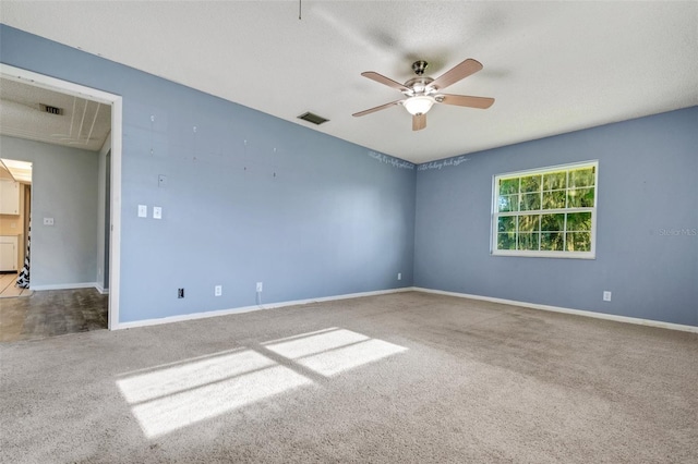 carpeted spare room with baseboards, visible vents, and a ceiling fan