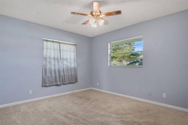 unfurnished room featuring a textured ceiling, ceiling fan, and carpet