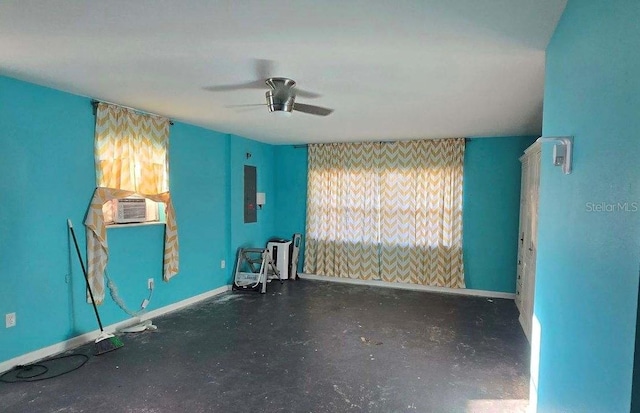 unfurnished room with a ceiling fan, cooling unit, electric panel, and baseboards