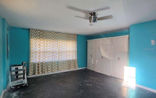 unfurnished bedroom with unfinished concrete flooring and baseboards