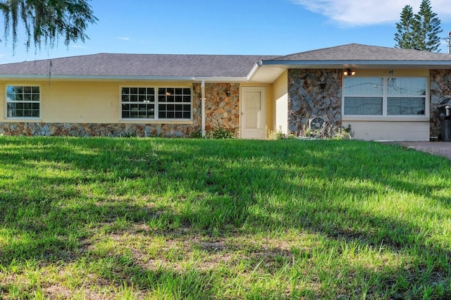 ranch-style house with stone siding and a front lawn