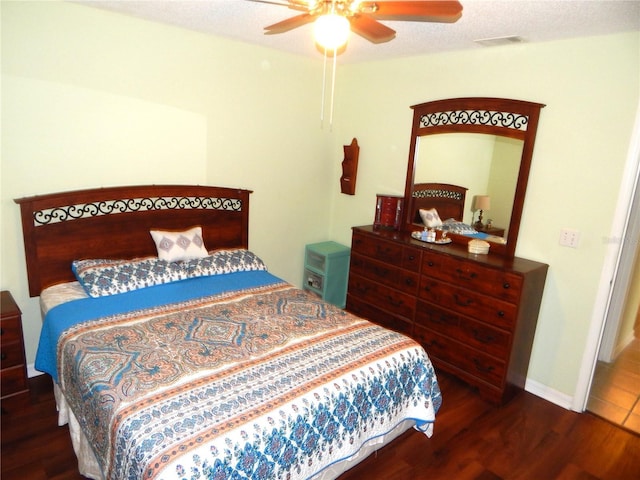 bedroom with dark hardwood / wood-style flooring, ceiling fan, and a textured ceiling