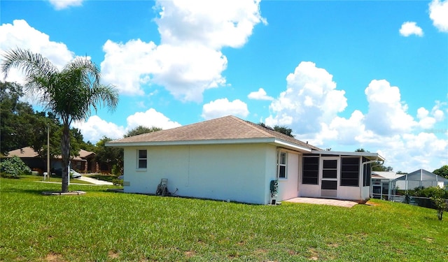 rear view of property with a lawn and a sunroom