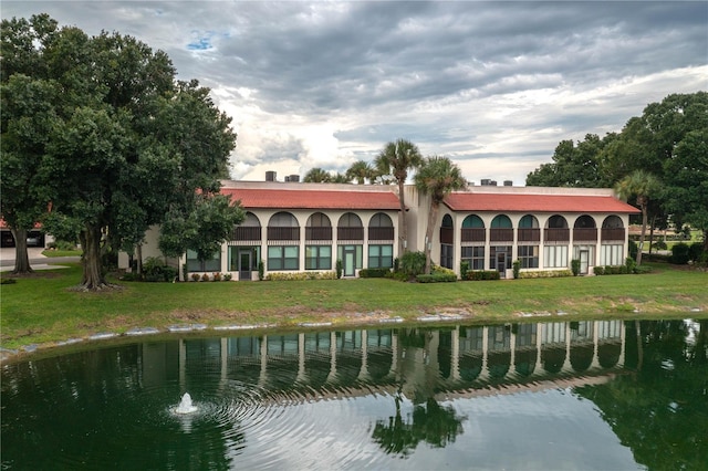 rear view of house with a yard and a water view