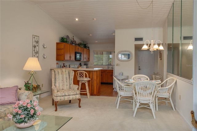 dining space with light carpet, visible vents, lofted ceiling, an inviting chandelier, and recessed lighting