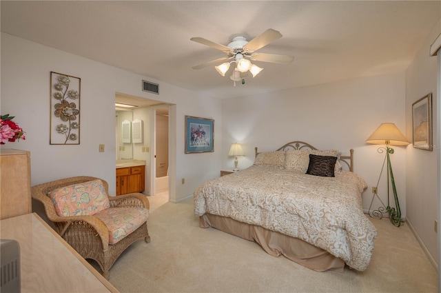 bedroom featuring ensuite bathroom, light carpet, a ceiling fan, baseboards, and visible vents