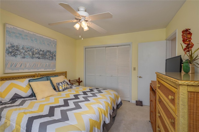 bedroom featuring light carpet, ceiling fan, and a closet