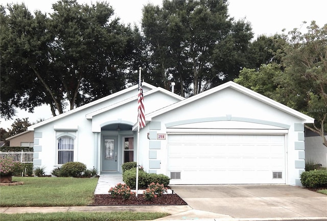 ranch-style house featuring an attached garage, a front yard, concrete driveway, and stucco siding