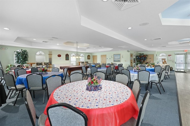 dining space with a raised ceiling