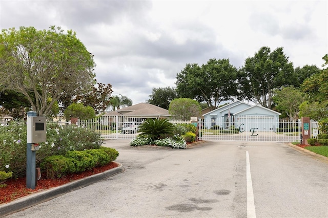 view of street featuring curbs, a gated entry, and a gate