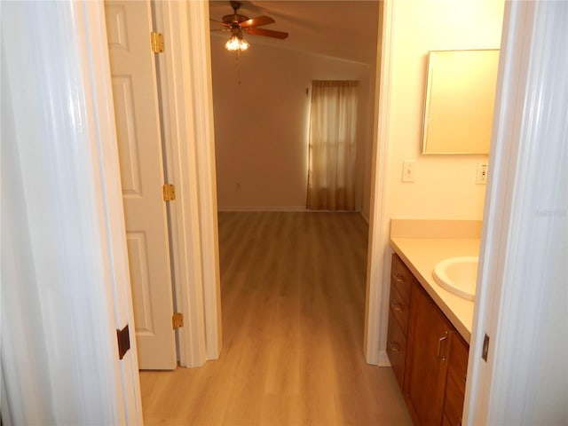 bathroom featuring ceiling fan, vanity, and wood-type flooring