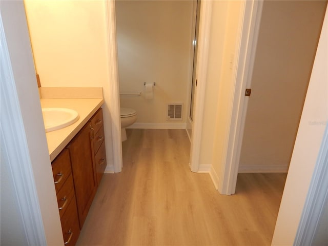 bathroom with vanity, hardwood / wood-style floors, and toilet