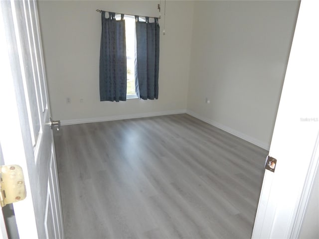 unfurnished room featuring wood finished floors and baseboards