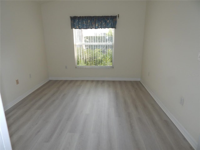 empty room featuring light wood-style flooring and baseboards