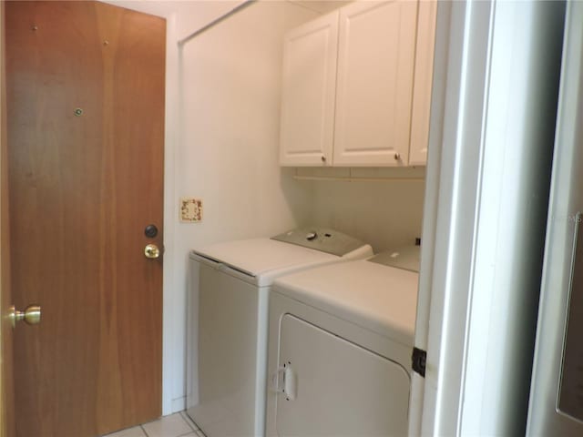 laundry room featuring cabinets, washing machine and clothes dryer, and light tile patterned flooring