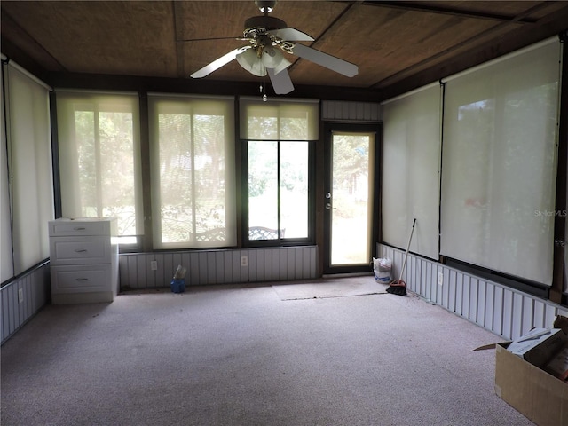 unfurnished sunroom featuring wood ceiling, ceiling fan, and plenty of natural light