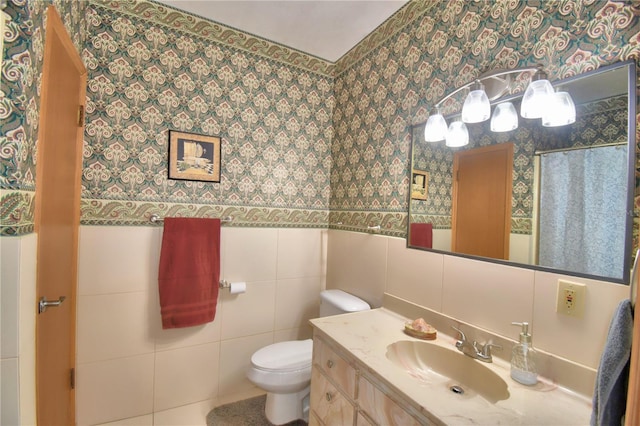 bathroom with vanity, tile walls, and toilet