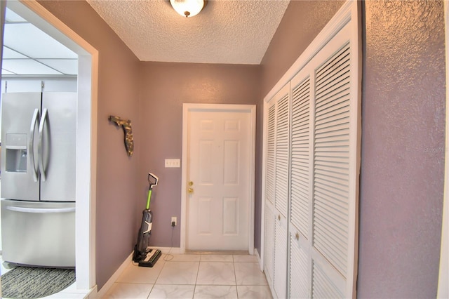 interior space with light tile patterned flooring and a textured ceiling