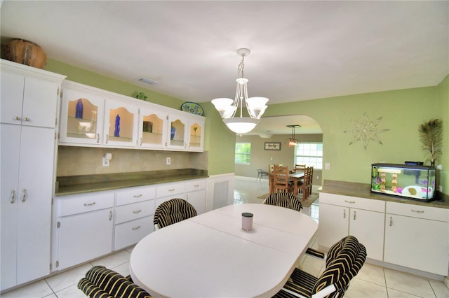 dining space with an inviting chandelier and light tile patterned floors