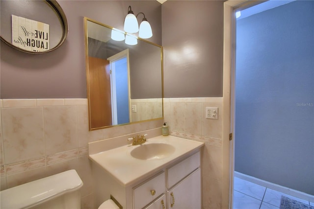 bathroom with tile walls, vanity, toilet, and tile patterned floors