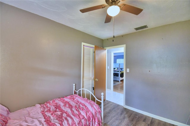 bedroom with a closet, wood-type flooring, and ceiling fan