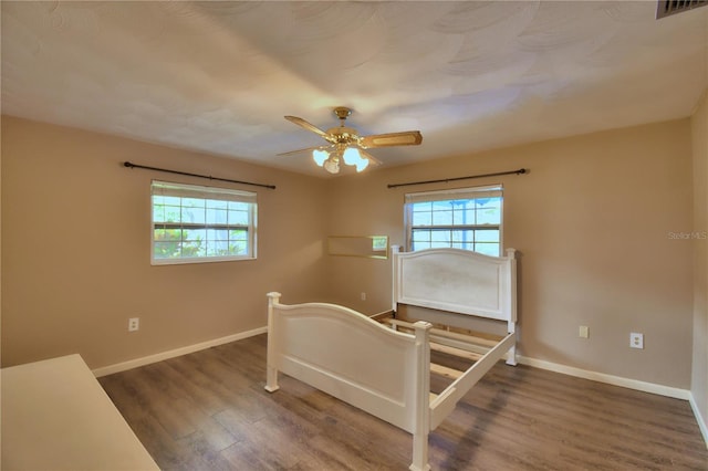 bedroom with ceiling fan and dark hardwood / wood-style flooring