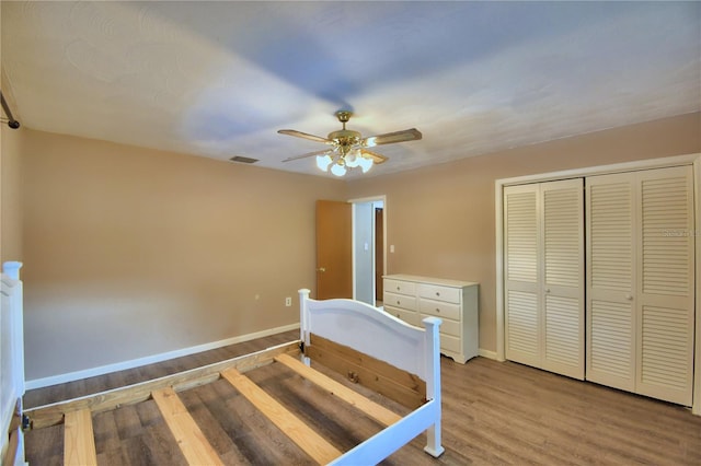 unfurnished bedroom featuring ceiling fan, a closet, and hardwood / wood-style flooring