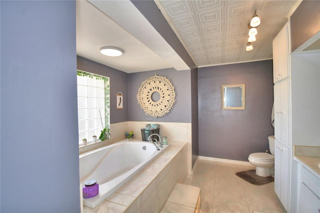 bathroom with tile patterned flooring, tiled bath, toilet, and vanity