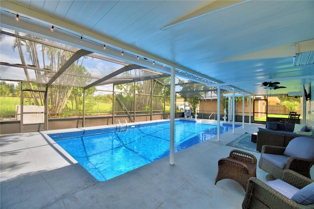 view of swimming pool featuring glass enclosure, ceiling fan, and a patio area