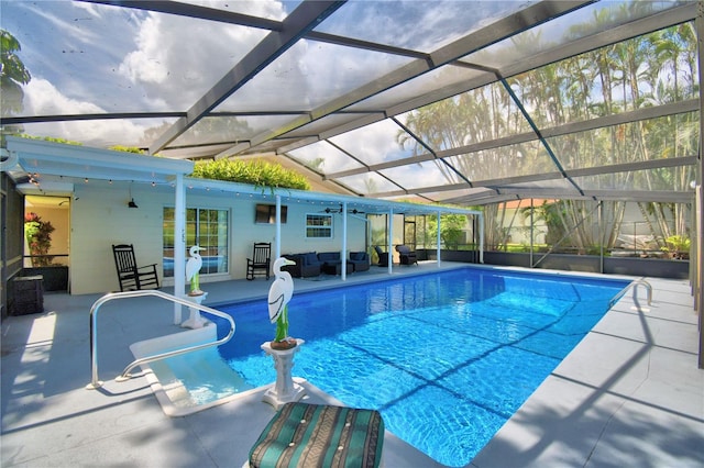 view of pool featuring a lanai, an outdoor living space, and a patio area