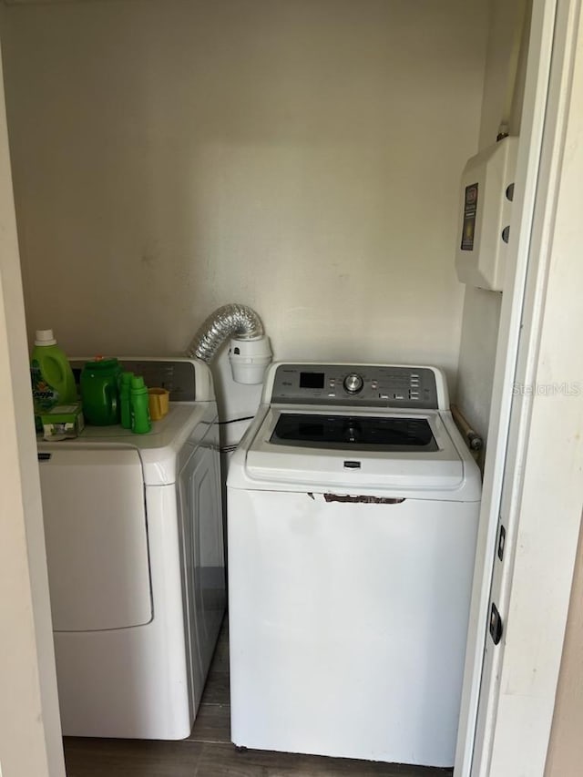 laundry area with separate washer and dryer and dark wood-type flooring