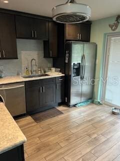 kitchen featuring dark brown cabinets, stainless steel appliances, light hardwood / wood-style flooring, and sink