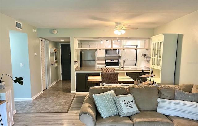 living room with ceiling fan and light hardwood / wood-style floors