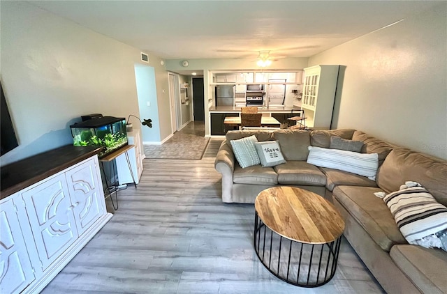 living room with ceiling fan and wood-type flooring