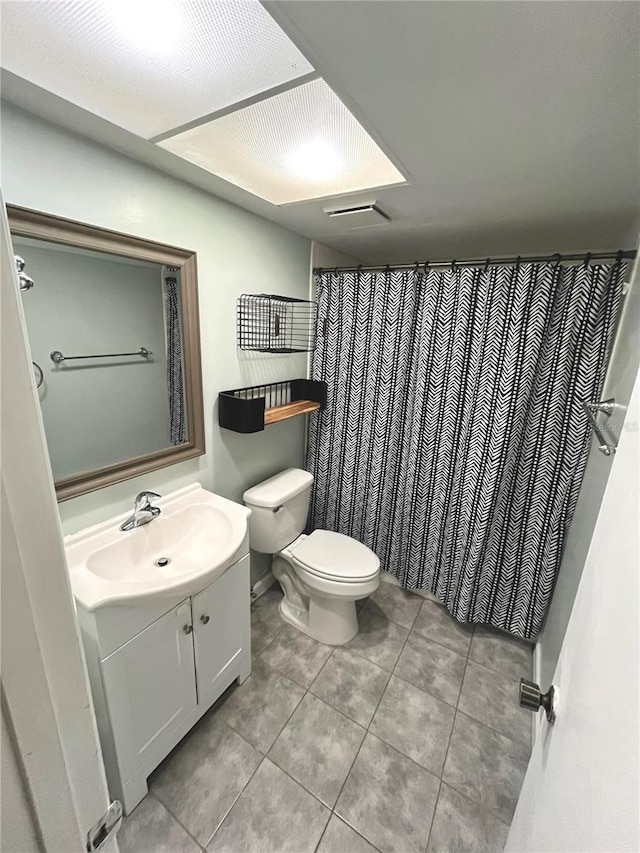 bathroom with tile patterned floors, vanity, toilet, and curtained shower