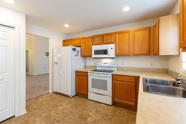 kitchen featuring light carpet, sink, and white appliances