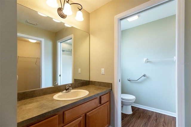 bathroom with toilet, vanity, and hardwood / wood-style floors