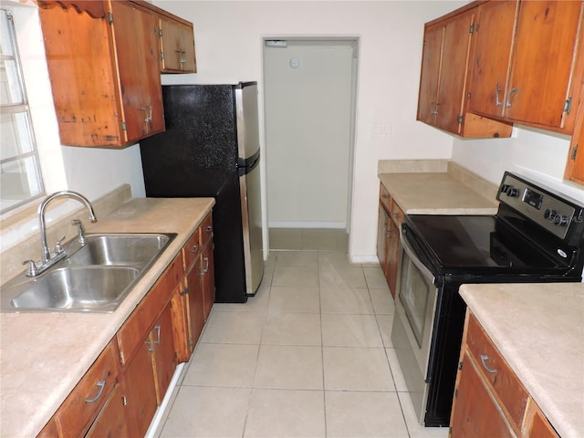 kitchen featuring sink, light tile patterned floors, and stainless steel appliances