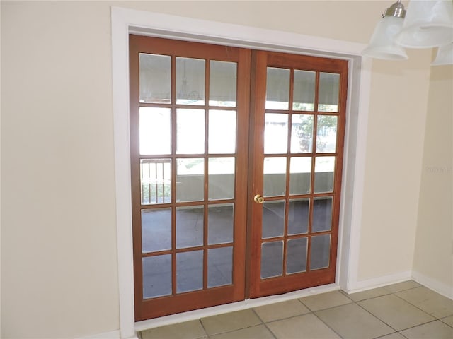 entryway featuring a chandelier, french doors, and light tile patterned floors