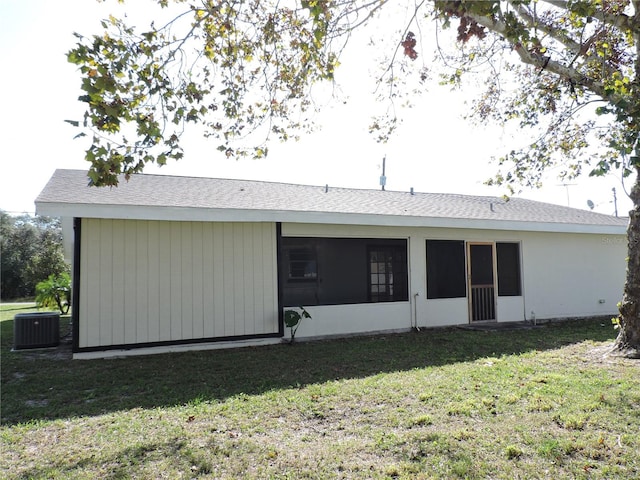 back of house featuring a sunroom, central AC, and a yard