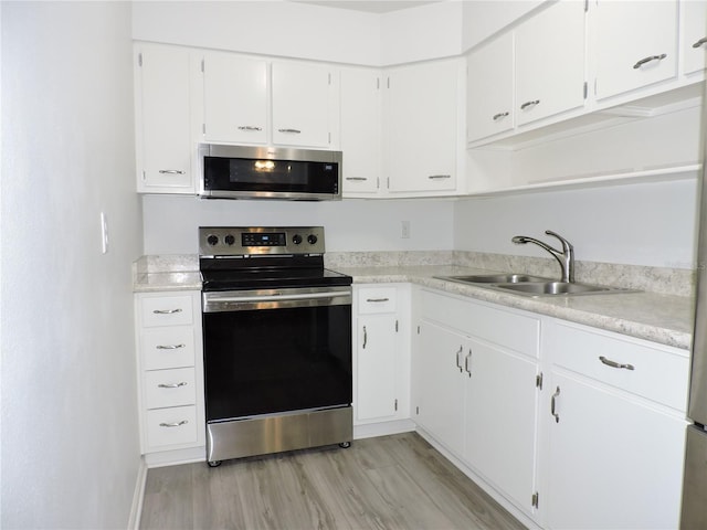 kitchen featuring white cabinets, light wood-type flooring, stainless steel appliances, and sink