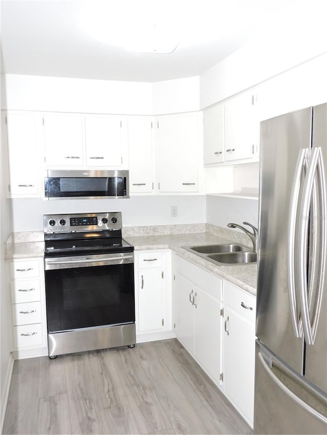 711 Springer Dr Unit 2, Lake Wales, FL 33853 - kitchen featuring stainless steel appliances, a sink, light countertops, and white cabinets