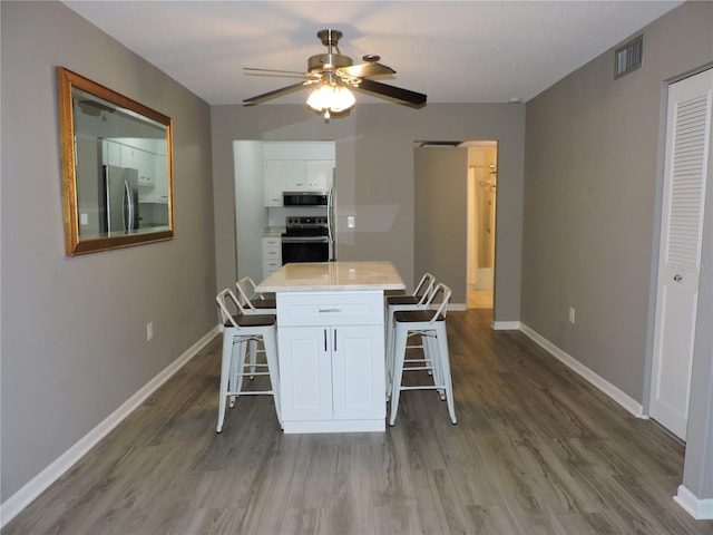 711 Springer Dr Unit 2, Lake Wales, FL 33853 - dining area featuring wood finished floors, a ceiling fan, and baseboards