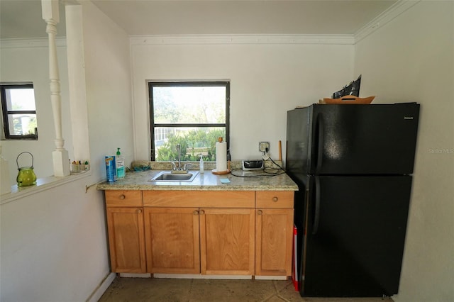 711 Springer Dr Unit 2, Lake Wales, FL 33853 - kitchen featuring freestanding refrigerator, a sink, brown cabinetry, and ornamental molding
