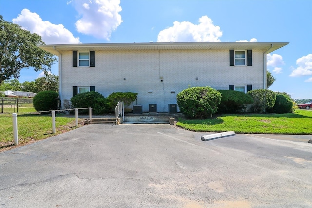 711 Springer Dr Unit 2, Lake Wales, FL 33853 - view of side of home with brick siding, uncovered parking, and central AC unit