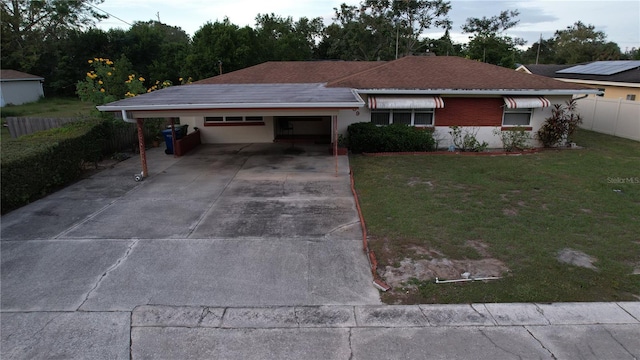 ranch-style house with a front yard and a carport