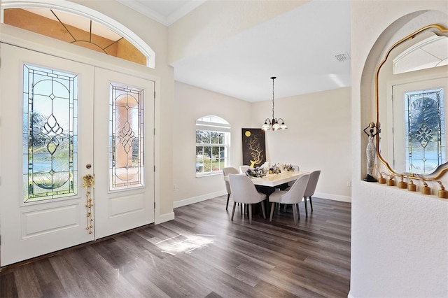 entrance foyer featuring a chandelier, french doors, crown molding, and dark wood-type flooring