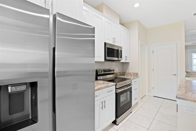 kitchen with backsplash, white cabinetry, light stone countertops, and stainless steel appliances